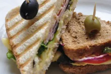 Zapečený toast s hummusem, šunkou, sýrem, rajčaty, salátem a cibulí